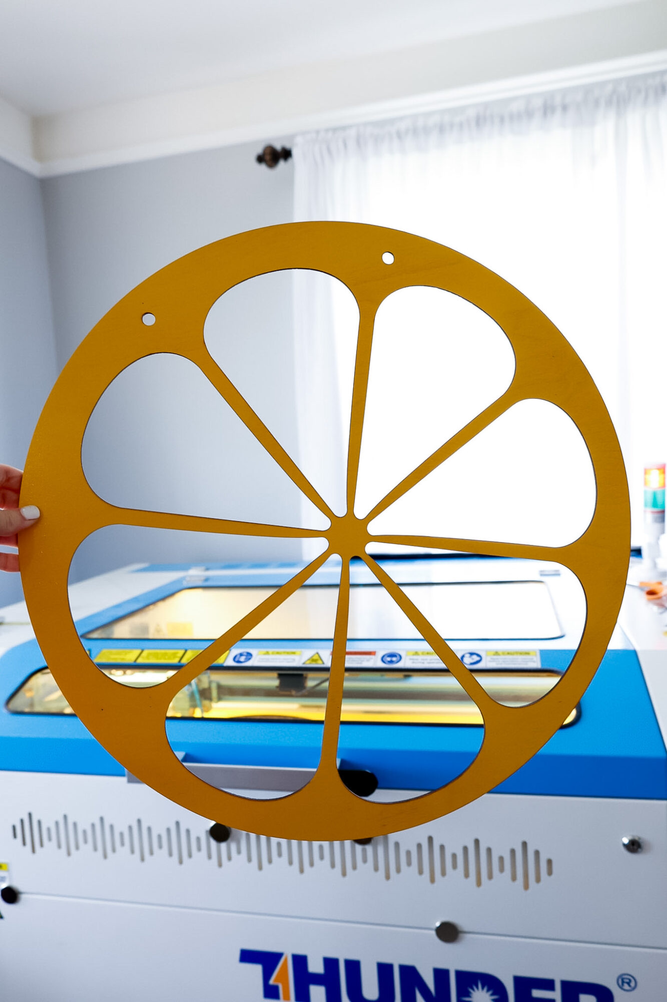 Finished Lemon Slice Outline wood cutting from laser machine held up