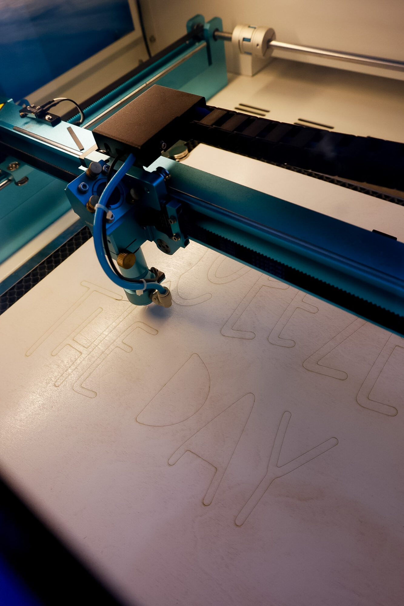 laser machine scoring line onto wood piece before cutting